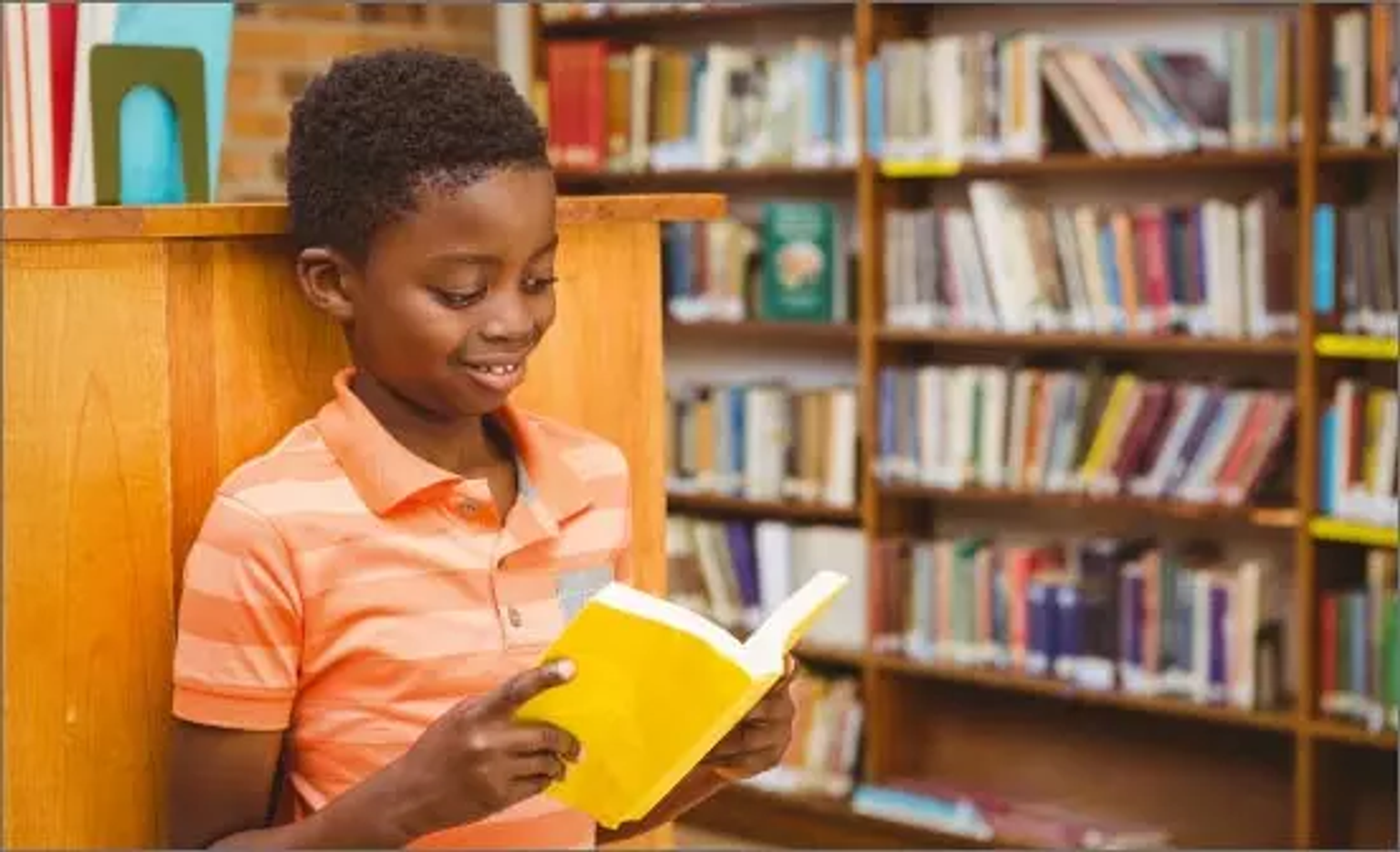 Banner com criança lendo um livro em uma biblioteca