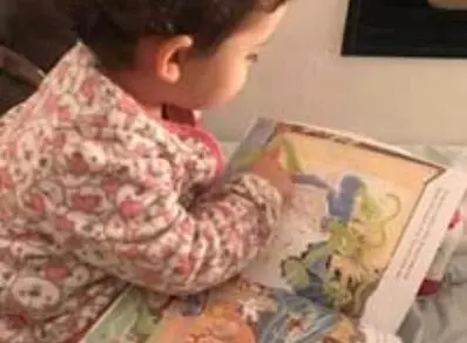 Foto contendo menina lendo um livro