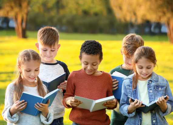 Crianças ao ar livre lendo livros