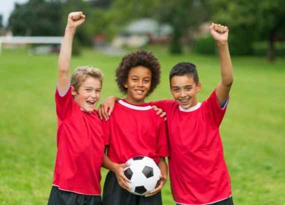 Jogo de futebol infantil. meninos jogando futebol no campo de