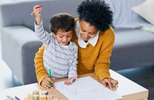 atividades para crianças 4 anos Mãe com seu filho pequeno desenhando e alguns cubos de alfabetização a seu lado