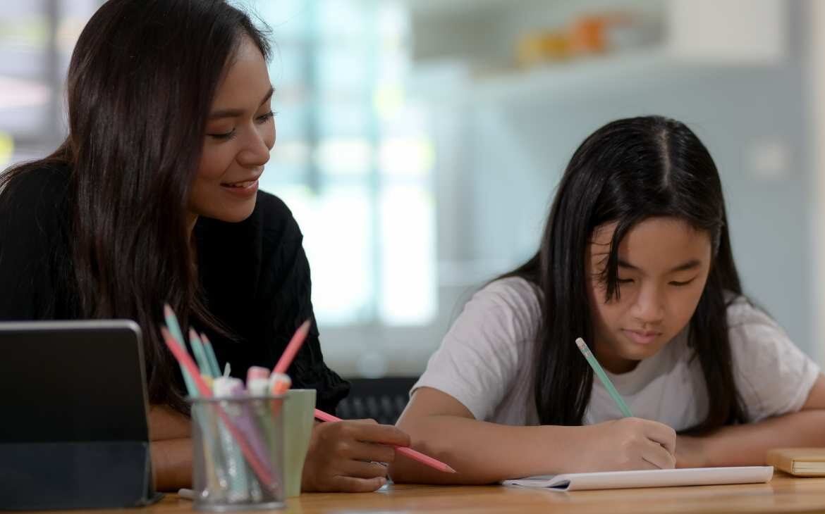 Mãe ajudando filha com as tarefas em casa. Homeschooling entenda o impacto do projeto de lei na educação brasileira capa