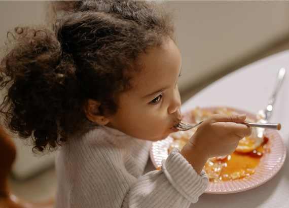 15 dicas para ajudar seus filhos durante a adaptação escolar. Menina comendo o almoço.
