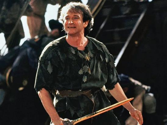 Peter Pan. Foto do ator Robin Williams como Peter Pan segurando uma pequena espada.