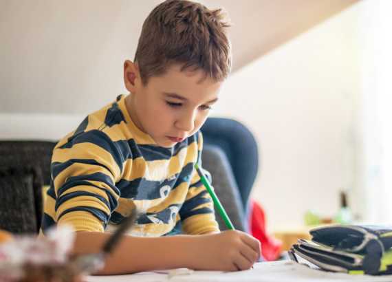 Criança superdotada: o que é superdotação, como identificar, acolher e apoiar?
Menino escrevendo em folha com lápis.