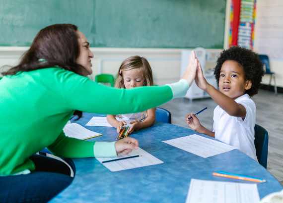 Criança superdotada: o que é superdotação, como identificar, acolher e apoiar?
Professora cumprimentando aluno, o felicitando.