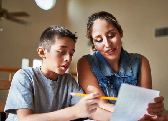 Criança superdotada: o que é superdotação, como identificar, acolher e apoiar?
Mulher adulta lendo escrito em papel com criança crescida segurando um lápis.