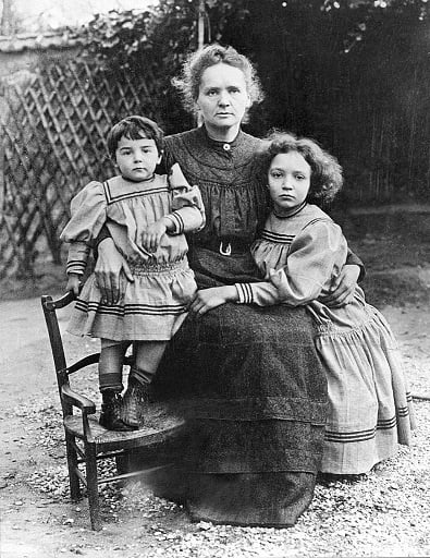 Mãe, cientista, mulher: a história de Marie Curie
Foto antiga de mulher sentada com duas crianças a seu lado.