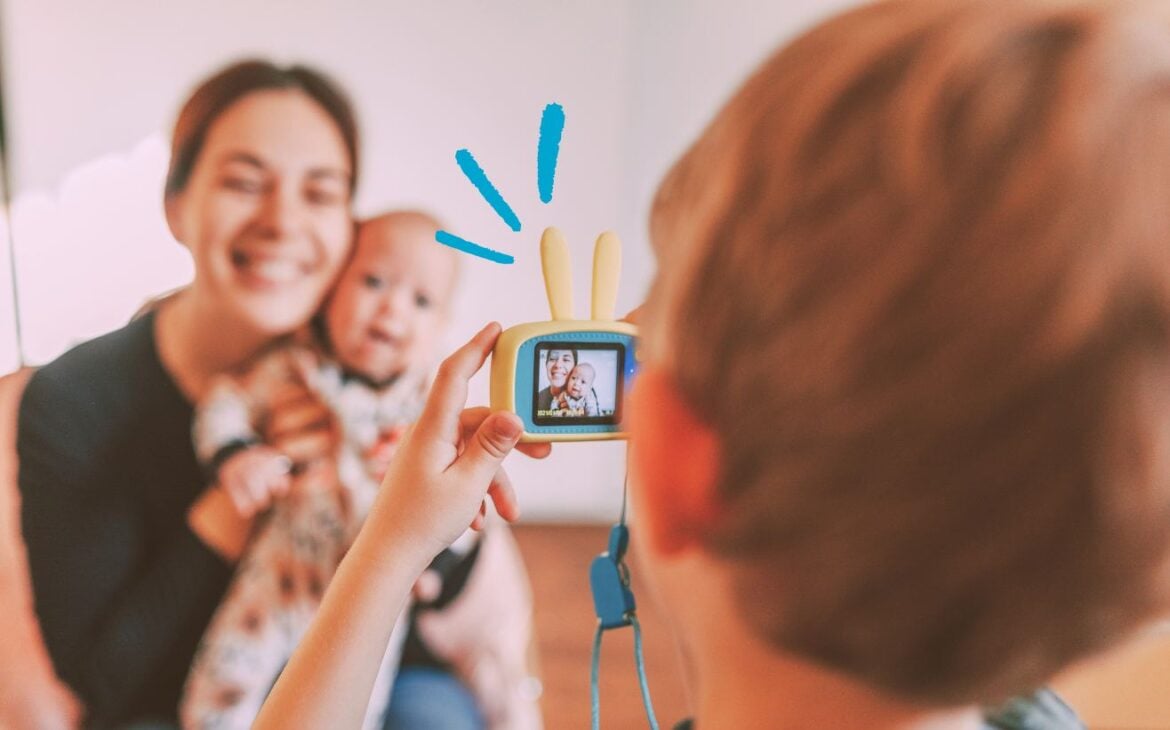 Criança tirando foto de mulher com bebê