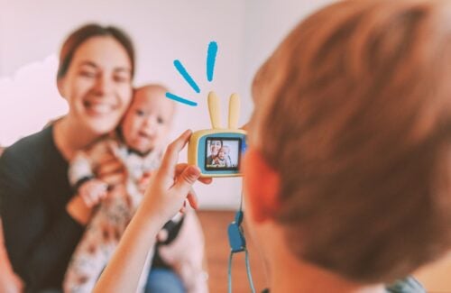 Criança tirando foto de mulher com bebê