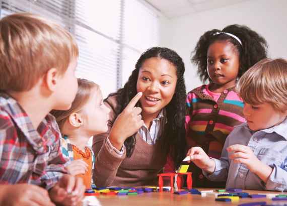 O que é crononormatividade? Veja como esse conceito influencia as infâncias 3 Crononormatividade_meio. Crianças na escola com professora