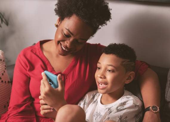 Você sabe o que seu filho faz na internet_meio. Filho compartilha algo no celular com a mãe