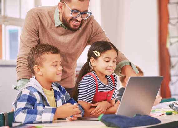 Excesso de telas: como a mente infantil reage a tantos estímulos? 4 Telas em excesso como a mente infantil reage a tantos estímulos_meio. Adulto e crianças no computador